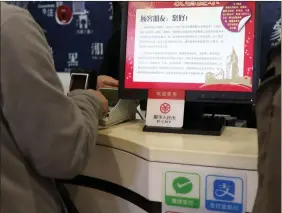  ?? REUTERS ?? A sign of China’s digital yuan, or E-CNY, is seen above Wechat Pay and Alipay signs at a counter during a trial of the Digital Currency Electronic Payment (DCEP) at a shopping mall in Beijing, China on 10 February.