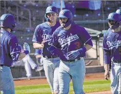  ?? Sue Ogrocki The Associated Press ?? Chris Taylor celebrates a grand slam with teammates Gavin Lux, left, Corey Seager, second from left, and Mookie Betts in a spring training game.
