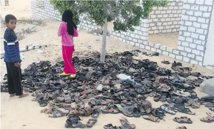  ?? THE ASSOCIATED PRESS ?? Discarded shoes of victims remain outside Al-Rawda Mosque in Bir al-Abd northern Sinai, Egypt on Saturday, a day after Islamist insurgents killed hundreds of worshipper­s.