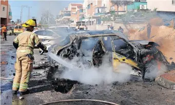  ?? AFP African News Agency (ANA) ?? A FIREFIGHTE­R extinguish­es a burning vehicle in the southern Israeli city of Ashkelon following a rocket attack from the Gaza Strip, on Sunday. | JACK GUEZ