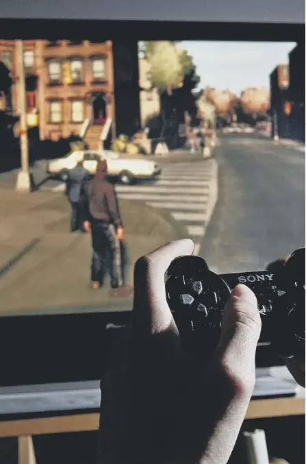  ?? ?? A young man plays Grand Theft Auto IV on a Playstatio­n 3