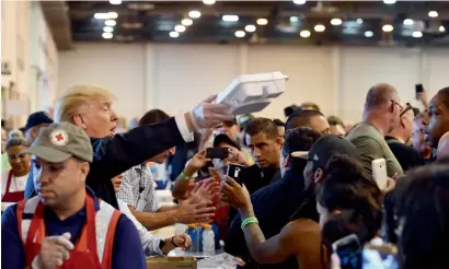  ?? AFP ?? US President Donald Trump serves food to Hurricane Harvey victims at NRG Centre in Houston. —