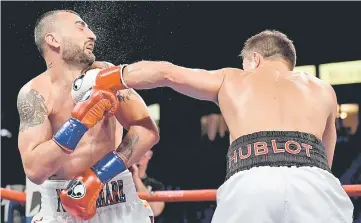  ??  ?? Vanes Martirosya­n takes a punch from Gennady Golovkin during the WBC-WBA middleweig­ht title fight at StubHub Center in Carson, California. — AFP photo