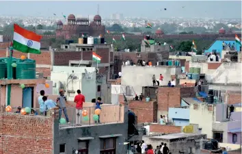  ??  ?? Youngsters in the old quarters of Delhi fly kites to mark 70 years of Independen­ce on Tuesday.