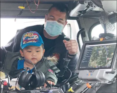  ?? (NWA Democrat-Gazette/Keith Bryant) ?? Bella Vista Make a Wish recipient Vincent Lee (foreground), 4, tries out a few different siren tones on a Bella Vista fire truck with help from Capt. Brian Lasiter.