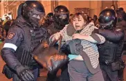  ?? ALEXANDER NEMENOV/AFP VIA GETTY IMAGES ?? Police officers detain a woman in Moscow on Wednesday following calls to protest against a partial mobilizati­on announced by President Vladimir Putin. Putin called up Russian military reservists, saying his promise to use all military means in Ukraine was “no bluff” and hinting Moscow is prepared to use nuclear weapons.