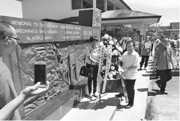  ??  ?? Dr Sim and Padawan Municipal Council councillor Amy Tnay placing a wreath at the WWII Memorial for Sarawak Volunteer Mechanics and Drivers.