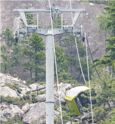  ?? DARRYL DYCK/THE CANADIAN PRESS ?? A gondola car rests on its side on the mountain after a cable was cut around 4 a.m. Saturday morning
at the Sea to Sky Gondola in Squamish, B.C., causing cable cars to crash to the ground below.