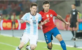  ??  ?? Lionel Messi y Eugenio Mena luchan por el control del balón.