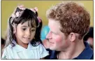  ??  ?? Little pleasures: Prince Harry holds three-year-old Mayara Pereira who was among the children to offer him such a warm welcome in the shanty town high above Rio