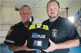  ?? MIKE ZETTEL METROLAND ?? Al Doneff, a paramedic and member of the Niagara Pedal Angels, delivers an automated external defibrilla­tor to Ray Napper, head coach at Napper’s Boxing Club in Welland.