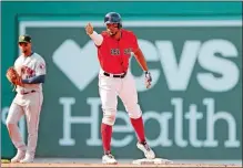  ?? WINSLOW TOWNSON/AP PHOTO ?? Xander Bogaerts of the Boston Red Sox signals towards his dugout after his RBI double against the Houston Astros during the seventh inning of Sunday’s game at Fenway Park in Boston.