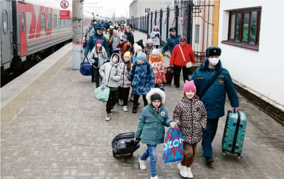  ?? ASSOCIATED PRESS ?? A group of 190 children (above) were evacuated Sunday from the Belgorod region in Russia due to ongoing Ukrainian artillery and drone strikes. A pilot (left) practiced with a drone in Kyiv.