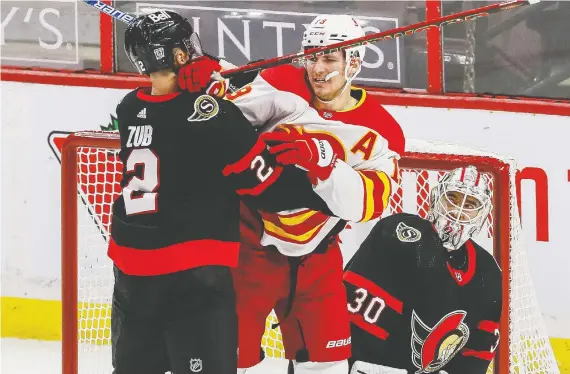  ?? ERROL MCGIHON ?? Ottawa defenceman Artem Zub tangles with Flames winger Matthew Tkachuk in front of goaltender Matt Murray during a 6-1 Senators victory in Ottawa on Thursday.