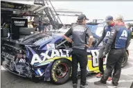  ?? Brian Lawdermilk / Getty Images ?? Hendrick Motorsport­s crew members work on the damaged car of Alex Bowman during practice at New Hampshire Motor Speedway on Saturday.