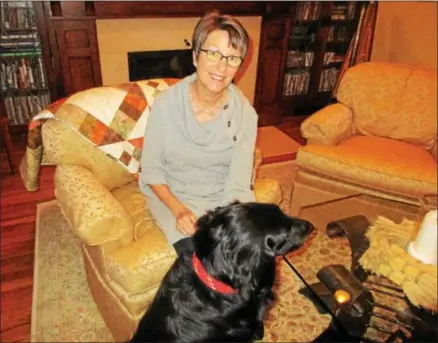  ?? PHOTO SPECIAL TO THE DISPATCH BY MIKE JAQUAYS ?? Bambi Niles of Oneida poses at her home on Nov. 14with her dog Dante and one of the quilts she has crafted on the back of her chair.