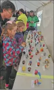  ??  ?? Children add their entries to the Easter egg decorating contest.