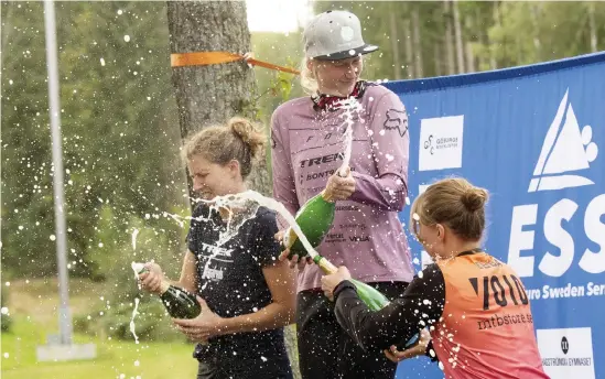  ?? Bild: Jari Välitalo ?? Josefine Björkman (i mitten) vann damklassen när Enduro Sweden Series nådde Hallandås. De var tre cyklister från Göteborgs Stigcyklis­ter i topp och efteråt sprutade Björkman, tvåan Elin Eng och trean Ebba Johansson glatt Pommac på varandra.