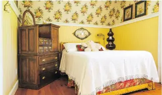  ??  ?? Adjacent to the master bedroom, the guest bedroom in this Rawdon home has a warm yellow theme with the top of the walls wallpapere­d and the lower half panelled.