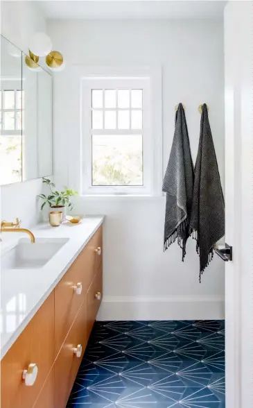  ??  ?? LEFT The owners’ daughters had redecorate­d their own bedrooms before this redesign, but Ami overhauled their bathroom. A long Ceasarston­e-topped fir vanity looks crisp paired with wall-mounted brass fixtures and chunky jewelry-like knobs, and offers loads of space for toiletries and bath linens. Tiles from Clé add dynamic pattern underfoot.