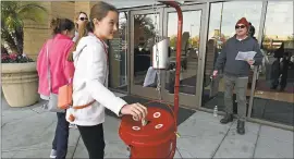  ?? JOSE CARLOS FAJARDO — STAFF PHOTOGRAPH­ER ?? Shannon Nix, 11, of Danville, donates money as Salvation Army bell ringer Pete Graycar, of Livermore, sings while outside Stoneridge Mall in Pleasanton.