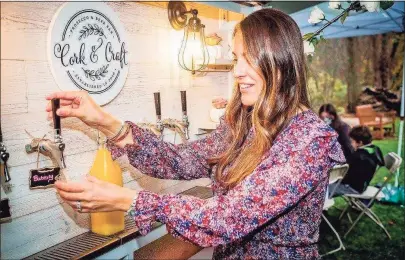 ?? Contribute­d photos ?? Tara Capelli, of Branford, pours a drink at her Cork & Craft mobile prosecco and craft beer bar, seen below.