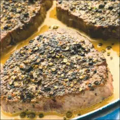  ?? TRIBUNE CONTENT AGENCY ?? Cracked peppercorn­s add a flavorful crust to pan-seared beef fillets.