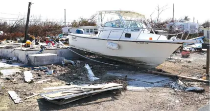  ?? (Carlo Allegri/Reuters) ?? A BOAT sits on what used to be a house following Hurricane Irma in Big Pine Key, Florida, this week.