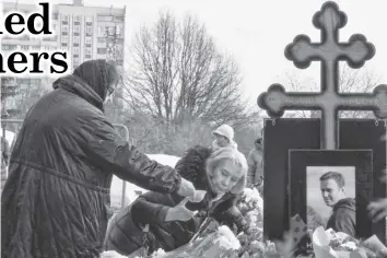  ?? AGENCE FRANCE PRESSE ?? Lyudmila Navalnaya (the woman wearing glasses), mother of late Russian opposition leader Alexei Navalny, accompanie­d by Alla, mother of Navalny’s widow Yulia, visits the grave of her son at the Borisovo cemetery in Moscow on March 2, 2024, the next day after Navalny’s funeral.