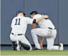  ?? KATHY WILLENS/THE ASSOCIATED PRESS ?? Yankees left fielder Brett Gardner, left, checks on center fielder Jacoby Ellsbury after Ellsbury collided with the outfield wall fielding a flyout in Wednesday’s game. Ellsbury left the game shortly after the collision.