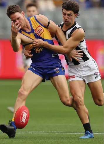  ??  ?? West Coast’s Jack Redden paddles the ball in front of him as Collingwoo­d’s Josh Daicos puts on the pressure in the Eagles’ big win at Optus Stadium. Picture: Paul Kane/Getty