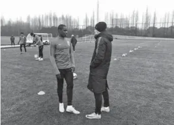  ??  ?? New signing Odion Ighalo of Nigeria talks with Shanghai Greenland Shenhua manager Enrique “Quique” Sanchez Flores at the Chinese Super League club’s training base in Pudong New Area yesterday. — Photo provided by Shenhua