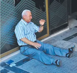  ??  ?? CASHED OUT: A retiree in tears outside a national bank branch in Greece.