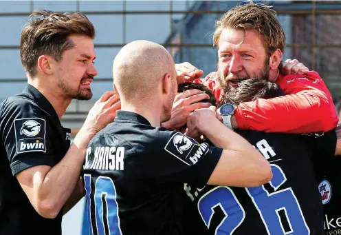  ??  ?? Der langjährig­e Erfurter Stammkeepe­r und heutige Torwarttra­iner Dirk Orlishause­n (rechts) jubelt mit Rostocker Spielern.
FOTO: IMAGO/NOAH WEDEL