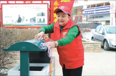  ?? PROVIDED TO CHINA DAILY ?? Wang Lanhua cleans a garbage bin in her community in Wuzhong, Ningxia Hui autonomous region.