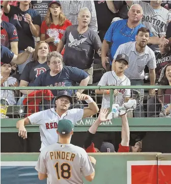  ?? STAFF PHOTO BY MATT STONE ?? IT’S GONE: Red Sox relief pitcher Joe Kelly jumps up in the bullpen trying to catch Jackie Bradley Jr.’s home run after it sailed over A’s right fielder Chad Pinder during the fifth inning of last night’s game.