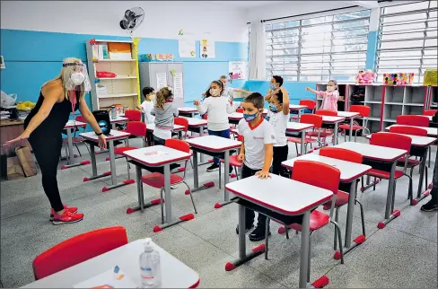  ?? FERNANDO BIZERRA / EFE ?? • Niños de la escuela paulista Raúl Antonio Fragoso participar­on ayer en el primer día de clases en la era del covid-19.