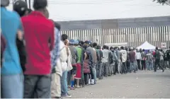  ?? AFP ?? Central American migrants line up for food outside a shelter in Tijuana on Saturday.