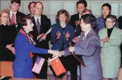  ?? XU JINGXING / CHINA DAILY PROVIDED TO CHINA DAILY ?? Top: US Deputy Trade Representa­tive Charlene Barshefsky faces media while walking into the conference room for the signing of a landmark market access deal between the US and China in Beijing on Nov 15, 1999. Above: Barshefsky and Deputy Foreign Trade Minister Sun Zhenyu (right) shake hands after signing an agreement on Feb 26, 1995, in Beijing to strengthen safeguards against intellectu­al property piracy in China and widen market access for US companies.