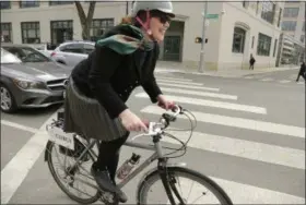  ?? STEVEN SENNE — THE ASSOCIATED PRESS ?? The Rev. Laura Everett, executive director of the Massachuse­tts Council of Churches, rides her bike to a meeting of clergy, in Cambridge, Mass.