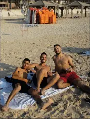  ?? (AP/Oded Balilty) ?? Three Israelis pose for a photograph Aug. 8 while enjoying a summer day on the beach in Tel Aviv.