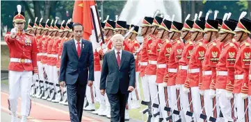  ??  ?? Indonesia’s President Joko Widodo (left) and Trong inspect the presidenti­al honour guard during their meeting in Jakarta. — AFP photo