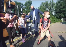  ??  ?? At top, John Thigpen and Kamara Taylor greet their daughter, Zaria Thigpen, 4, after her first ride on a school bus on the first day of school at Mead School on Thursday. Above, Superinten­dent of Schools Steve Bergin guides students off the bus on Thursday. At left, Mickey Mouse greets students on the first day of school.