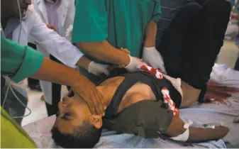 ?? Khalil Hamra / Associated Press ?? A Palestinia­n youth receives treatment after being shot by Israeli troops at the Gaza border. Israel pounded Hamas targets in its largest bombardmen­t campaign since the 2014 war.