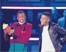  ?? Kevork Djansezian Getty Images ?? ASHTON SANDERS, left, and Jharrel Jerome accept the best kiss award for “Moonlight.” Other winners included Emma Watson for “Beauty and the Beast.”