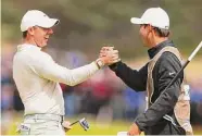  ?? Andrew Redington/Getty Images ?? Rory McIlroy, left, celebrates with caddie Harry Diamond after a birdie on No. 18 to win Sunday.