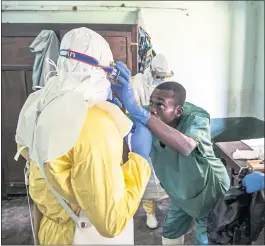  ?? MARK NAFTALIN — UNICEF VIA THE ASSOCIATE PRESS ?? WHO officials hope vaccinatio­ns can begin by Sunday for an experiment­al Ebola vaccine. Above, health workers don protective covering at Bikoro Hospital in Congo.
