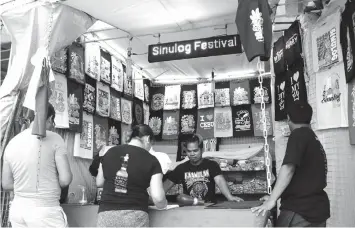  ?? TRISTAN LAPUT, ?? Sinulog shirts are now being sold at the stalls along Osmeña Boulevard. The Cebu City government is asking all vendors to register with DWUP until December 29.