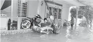  ?? — Gambar Bernama ?? BANJIR: Penduduk kampung cuba menyelamat­kan motosikaln­ya selepas rumahnya dinaiki air akibat fenomena air pasang besar di Kampung Batu 5, Jalan Kapar, semalam.