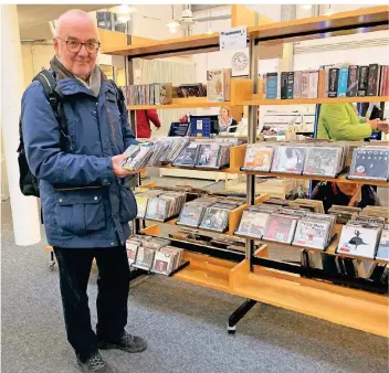  ?? FOTO: LEA HENSEN ?? Wolfgang Schindler findet viele Schnäppche­n unter den aussortier­ten CDs der Bibliothek.